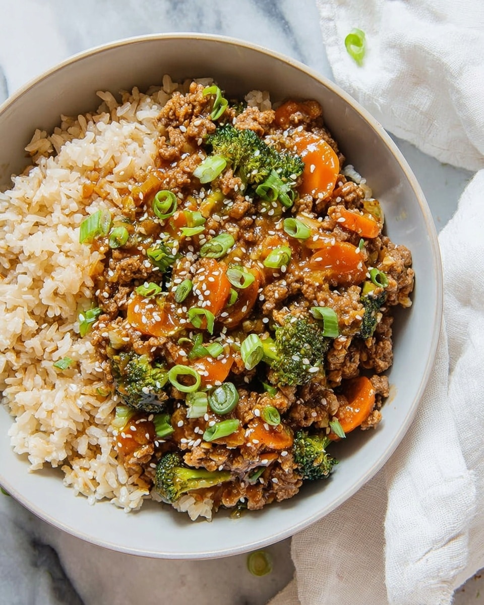 A white bowl filled with a base layer of light brown cooked rice with a slightly soft texture. On top, there is a mixture of cooked ground meat and small broccoli pieces, coated in a thick, glossy brown sauce. Thin strips of orange carrot are mixed in with the meat, along with small green onion slices scattered on top. White sesame seeds are sprinkled over the entire dish, adding small white dots for texture contrast. The bowl rests on a white marbled surface, with part of a white cloth visible on the left side. photo taken with an iphone --ar 4:5 --v 7