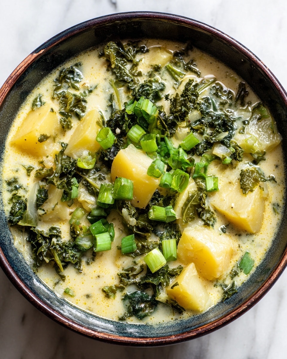 A close-up of a thick soup in a white bowl with a smooth, creamy yellow base. Large soft potato chunks are scattered throughout the soup, with the yellow creamy texture surrounding them. Dark green kale leaves are mixed in and slightly wilted, sitting just under the surface. Bright green chopped scallions are sprinkled on top in small pieces, adding a fresh contrast. The bowl is on a white marbled texture surface and is shown from a side angle, making the soup look warm and comforting. photo taken with an iphone --ar 4:5 --v 7